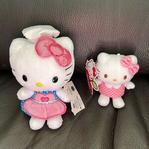 Two hello kitty stuffed animals with polka dot outfits